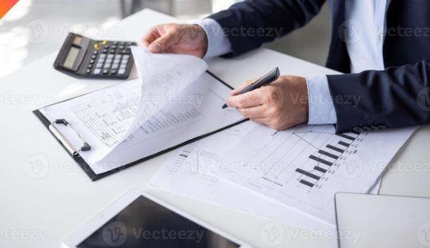 Consultant reviewing forms and statements with a calculator